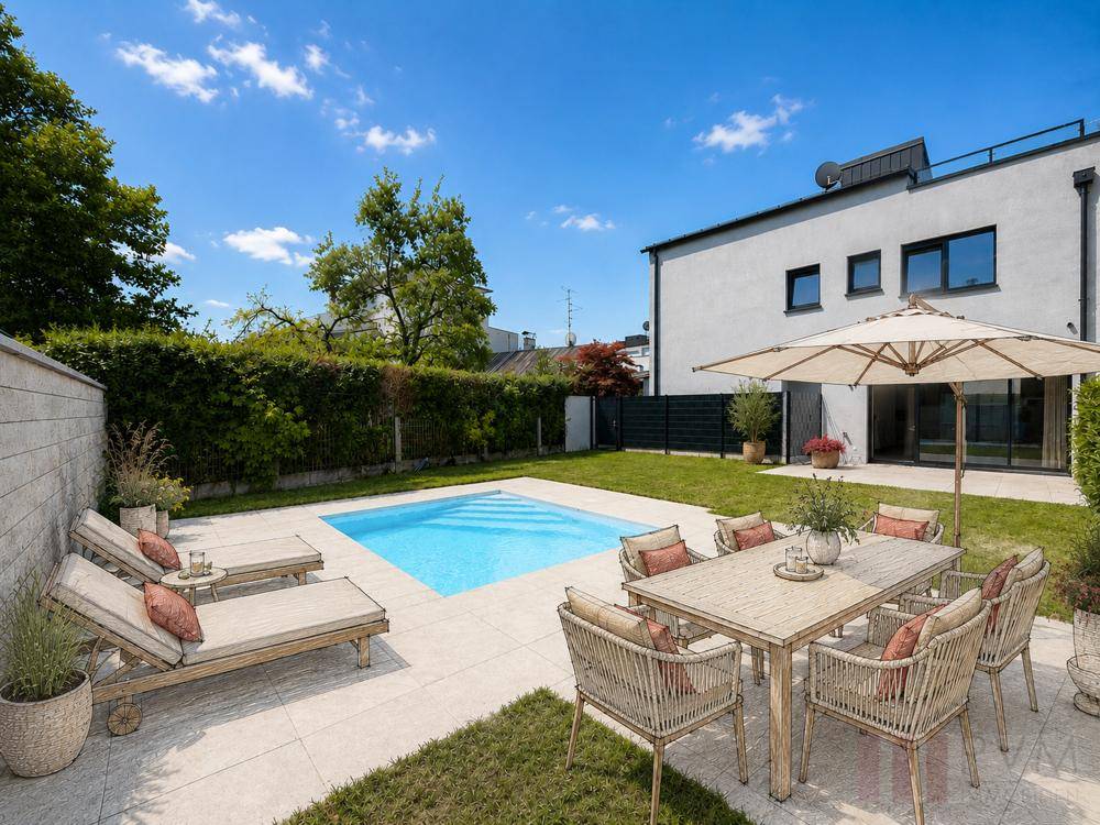 Sonniger Gartenbereich mit Pool, Liegestühlen und Essbereich im Freien hinter dem Haus.