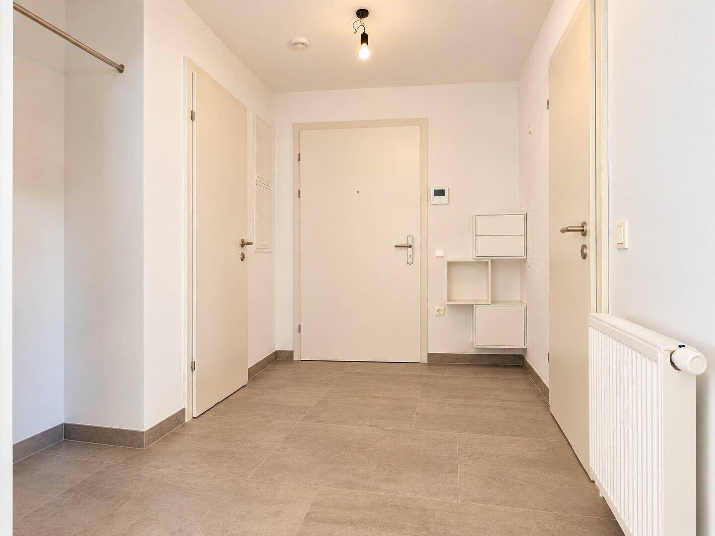 Geräumiger Eingangsbereich mit Fliesenboden und mehreren Türen.