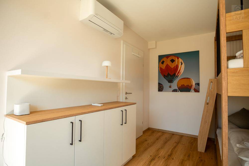 Helles Zimmer mit Etagenbett, Klimaanlage und praktischen Schränken für zusätzlichen Stauraum.