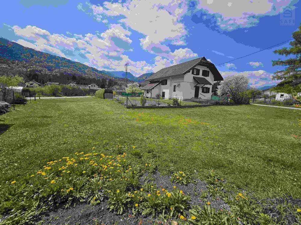 Freistehendes Haus mit großem Rasengrundstück und Blick auf die umliegenden Berge.