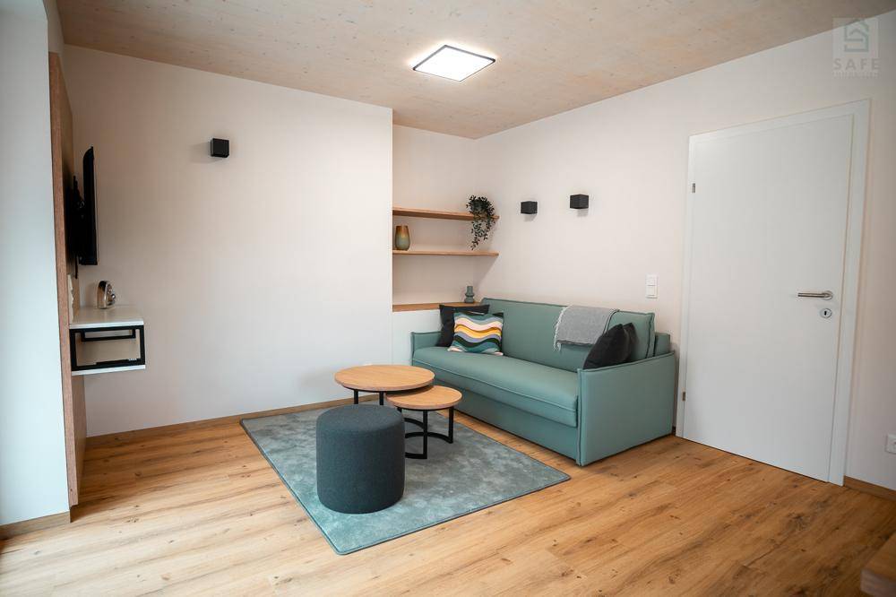 Helles Wohnzimmer mit modernem Sofa, Holzboden und minimalistischer Einrichtung für entspannte Stunden.