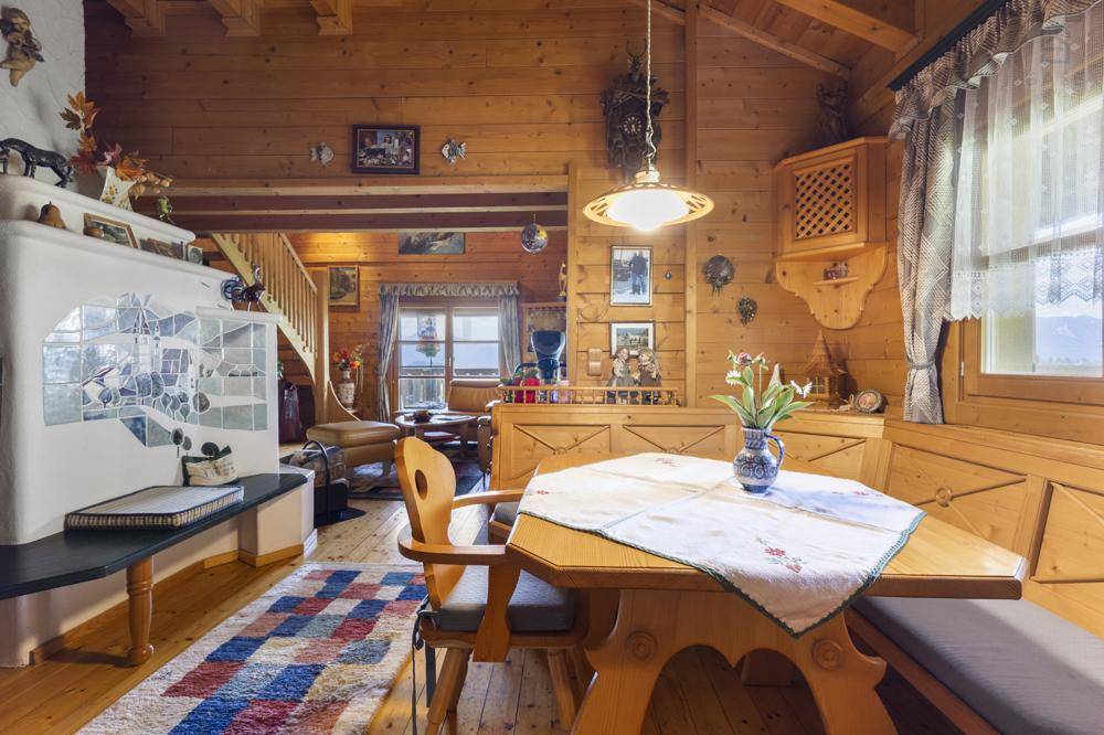 Rustikaler Essbereich mit Holztisch und Bänken, Teil eines offenen Wohnkonzepts mit Holzboden.