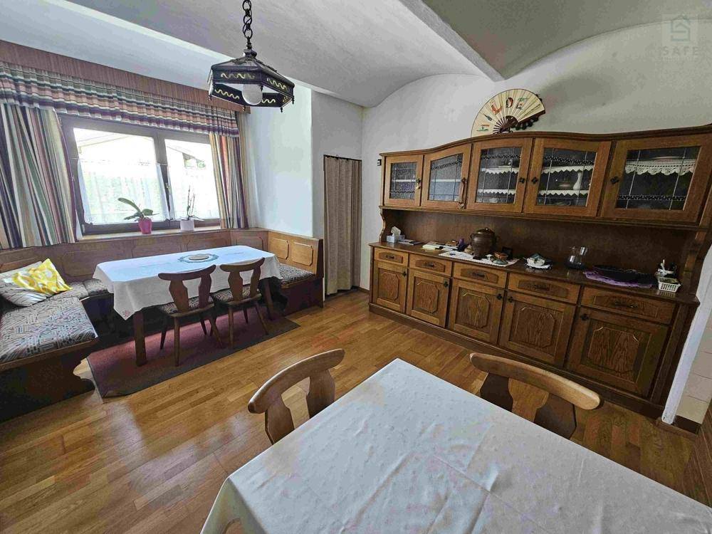 Gemütlicher Essbereich mit traditioneller Eckbank, Holztisch und rustikalem Holzschrank.