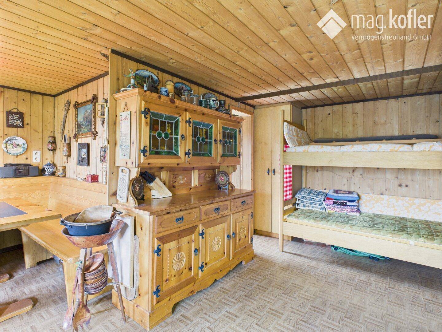 Gemütliches Zimmer mit Holzvertäfelung, traditionellem Schrank und Etagenbetten.