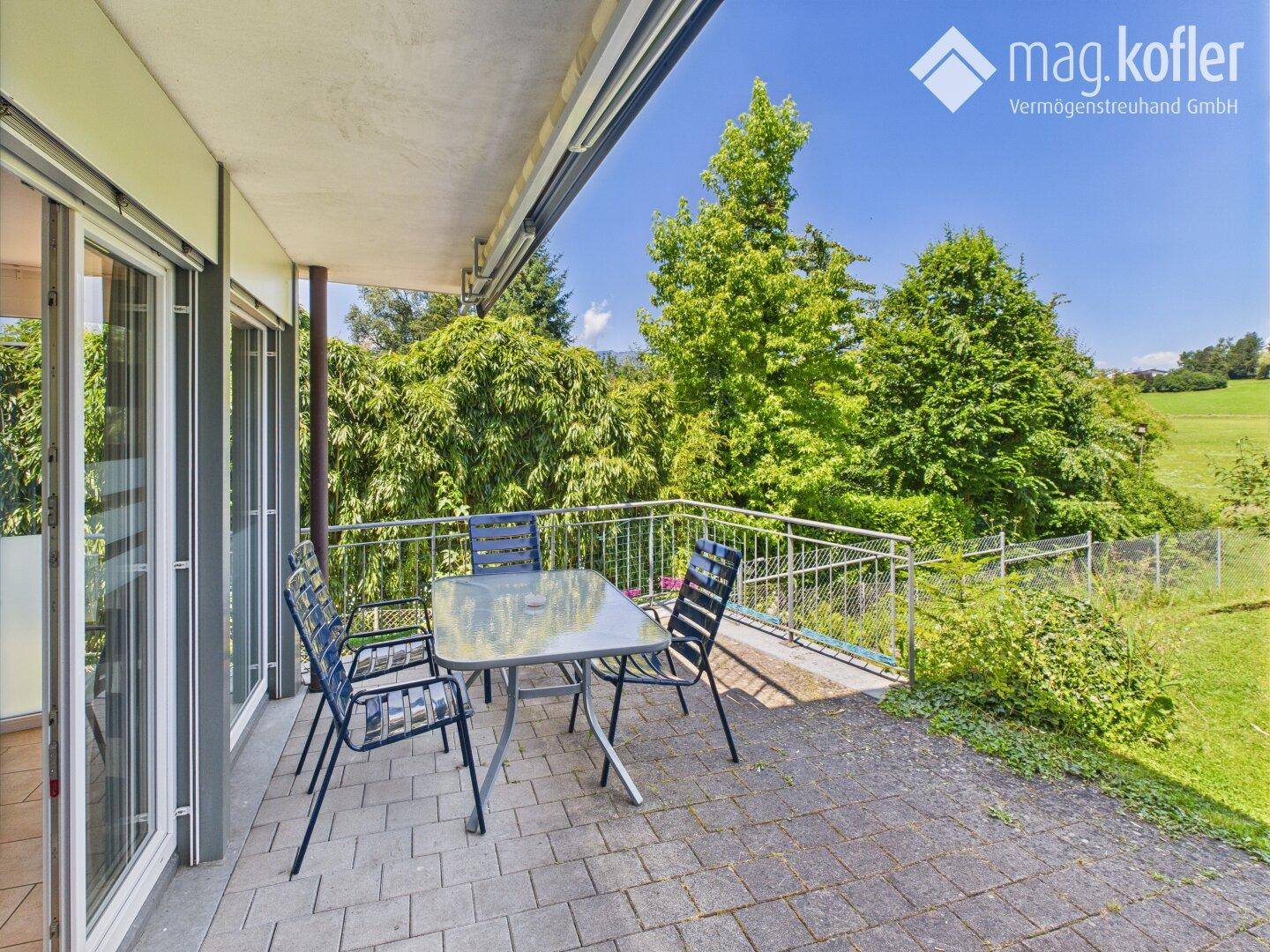 Gemütliche Terrasse mit Sitzgelegenheiten und Blick auf die umliegende grüne Natur.