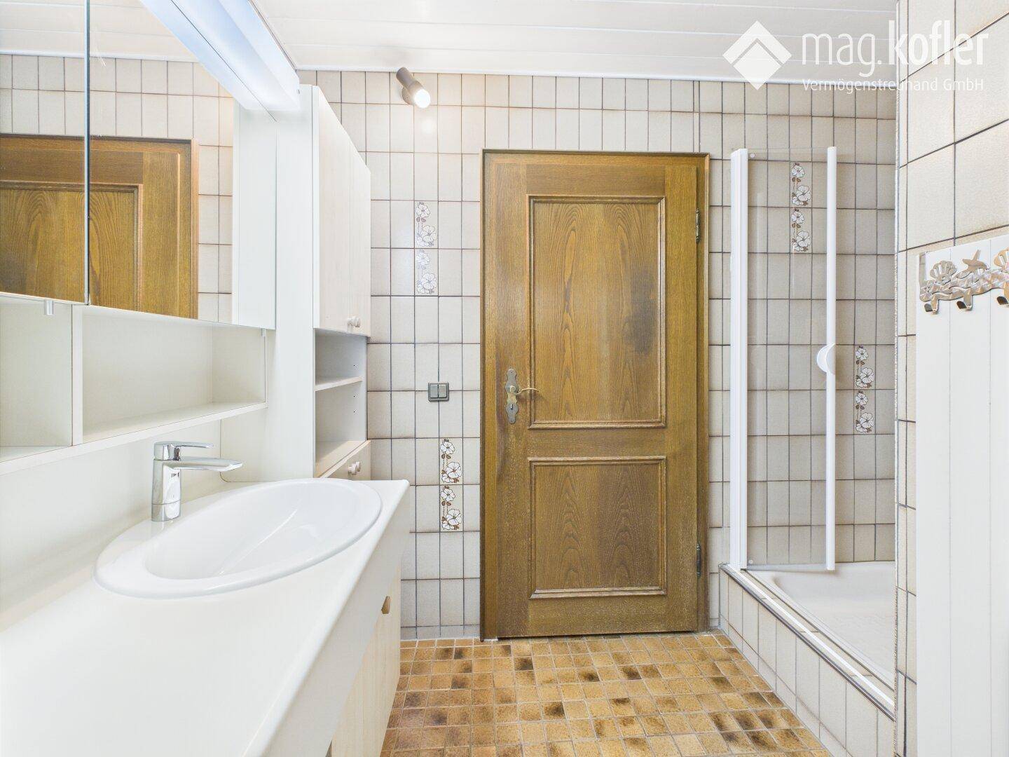 Badezimmer mit Dusche, Einzelwaschbecken und Fliesen im traditionellen Stil.