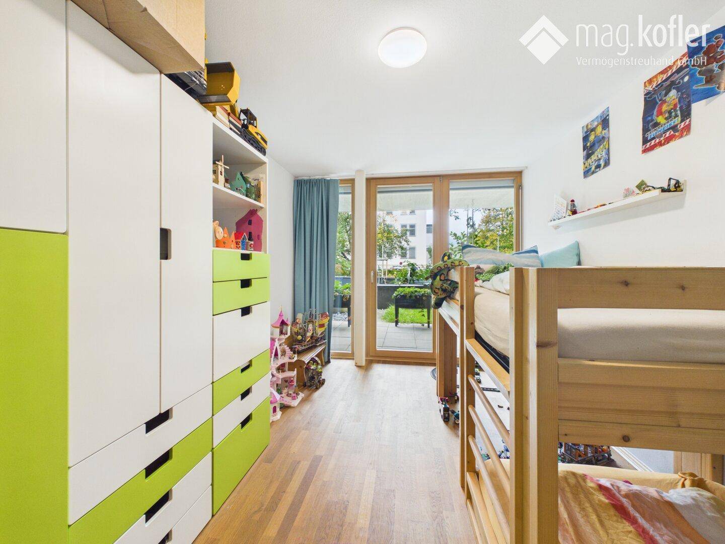 Kinderzimmer mit Etagenbett, Schrank und Zugang zum Balkon oder Garten.