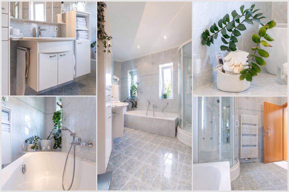 Geräumiges Badezimmer mit Badewanne, Duschkabine, Waschtisch und Fenster für Tageslicht.