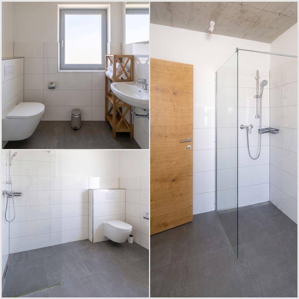 Modernes Badezimmer mit ebenerdiger Dusche, wandhängendem WC und Fenster.