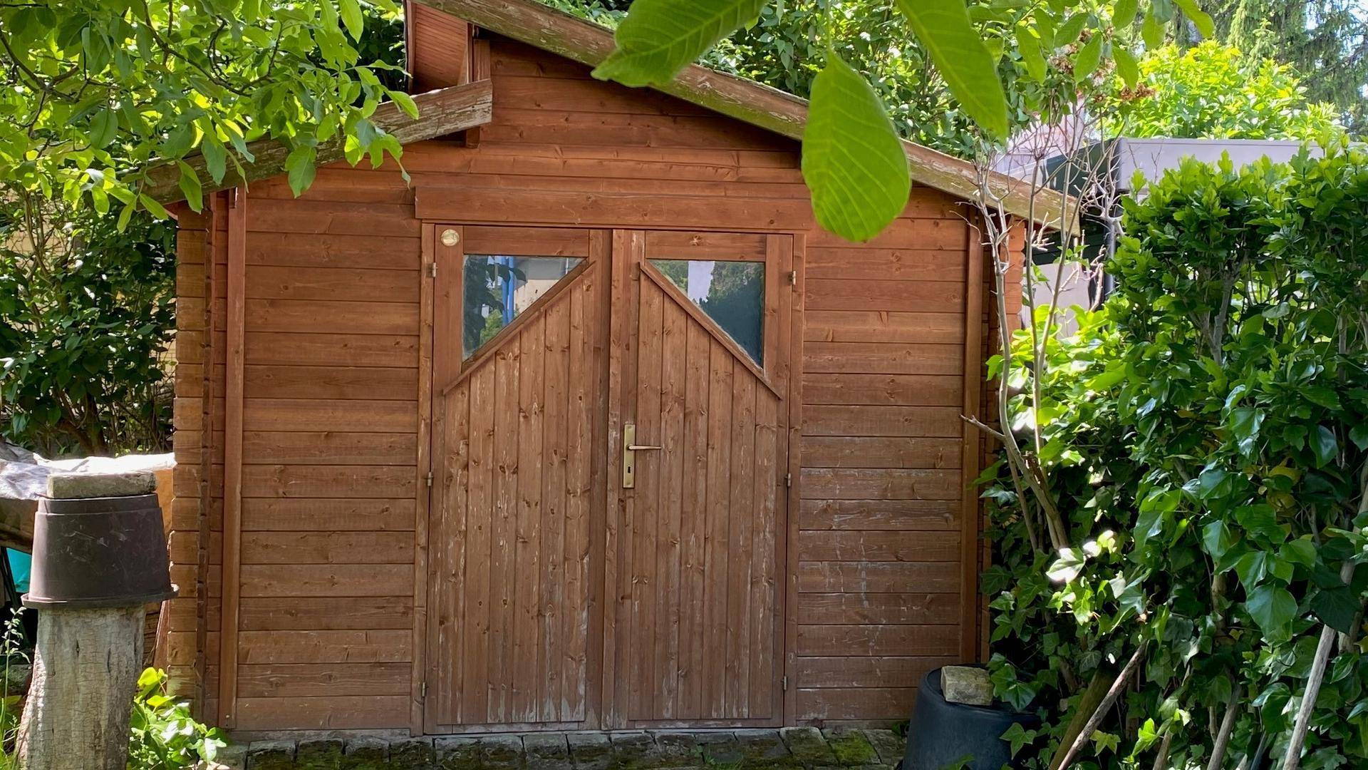 Rustikaler Holzschuppen im Garten, ideal zur Aufbewahrung von Gartengeräten.