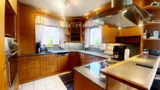 Traditionelle Holzküche mit Granitarbeitsplatten, Einbaugeräten und Kochinsel.