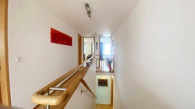 Heller Flur mit Holzgeländer und Treppe, die zu den oberen Etagen führt.
