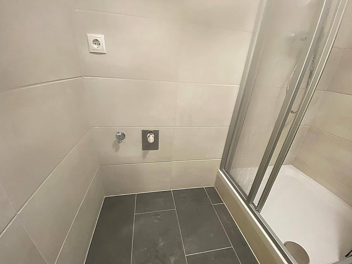 Duschbereich im Badezimmer mit modernen Fliesen und Glasduschkabine.