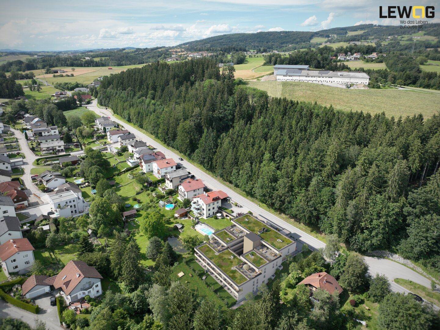 Weitläufige Luftaufnahme der Wohnanlage in ländlicher Umgebung mit viel Grün und Wald.