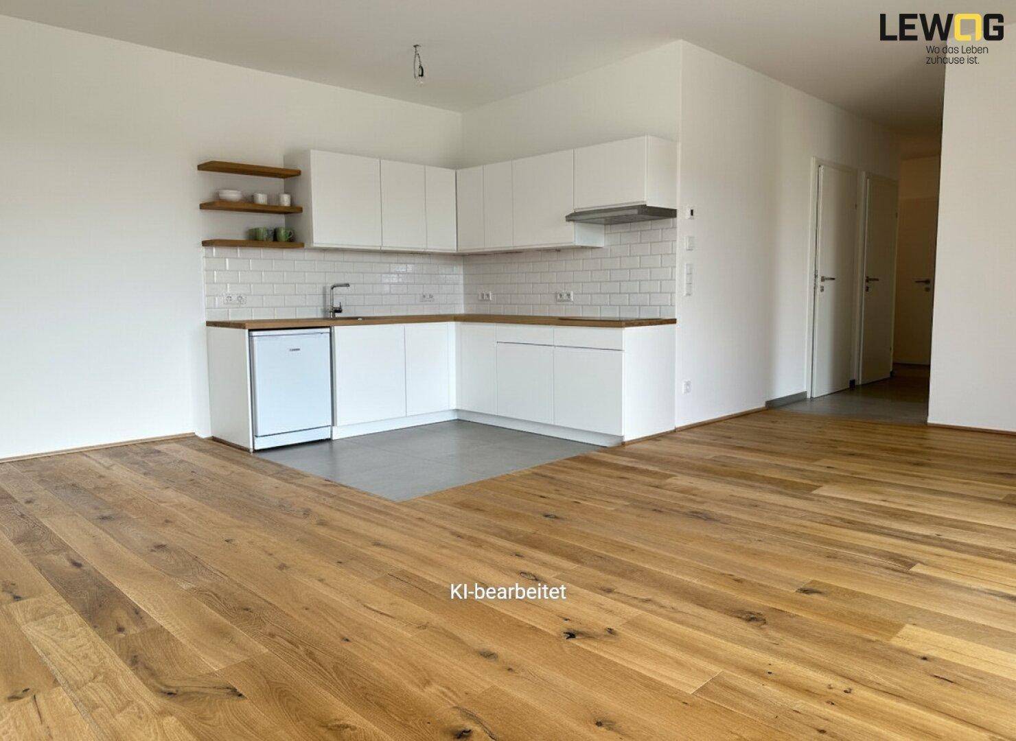 Offene Küche mit weißen Schränken, Holztheke und Fliesenboden, bereit für die Installation von Geräten.