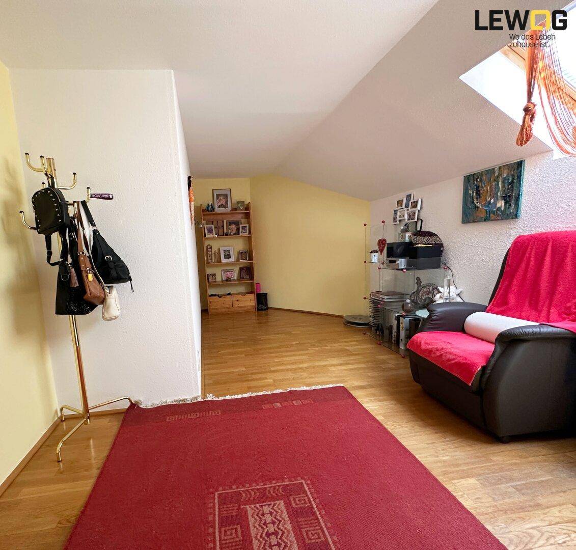 Geräumiger Flur im Dachgeschoss mit Laminatboden, Dachfenster und Garderobe.