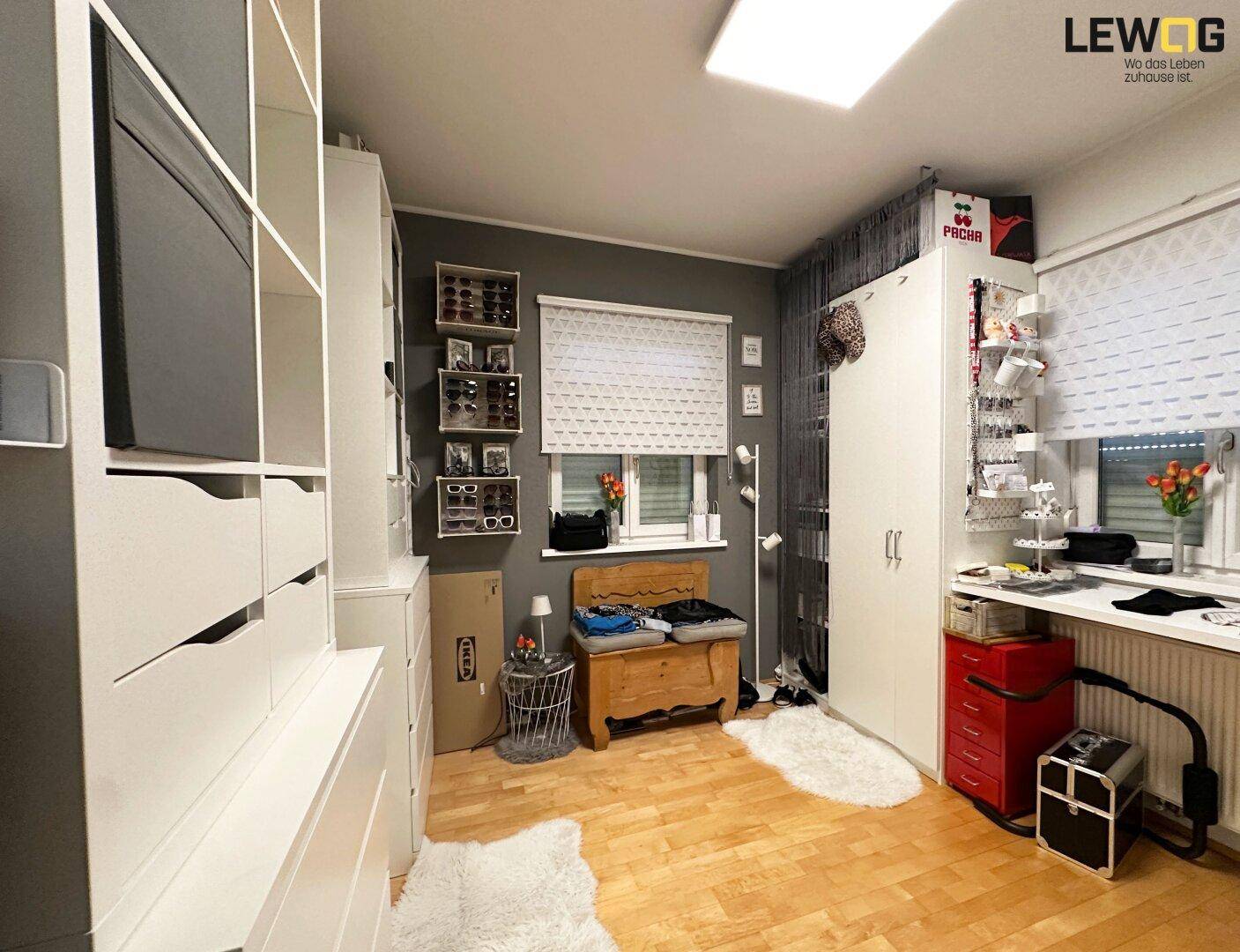 Schlafzimmer mit viel Stauraum, Schränken und hellem Holzfußboden.