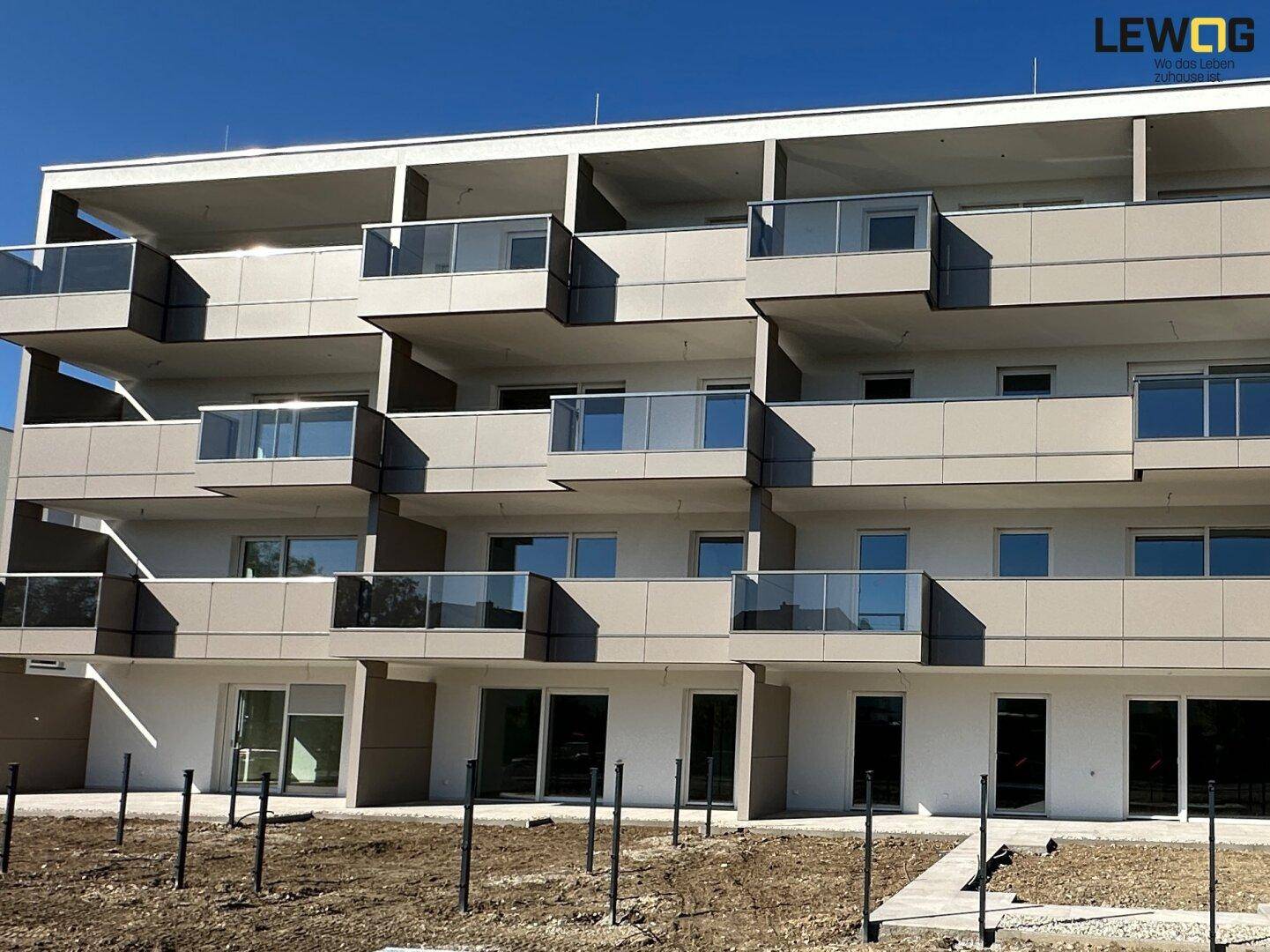 Ansicht eines modernen Wohngebäudes mit gestaffelten Balkonen und großen Fensterfronten.
