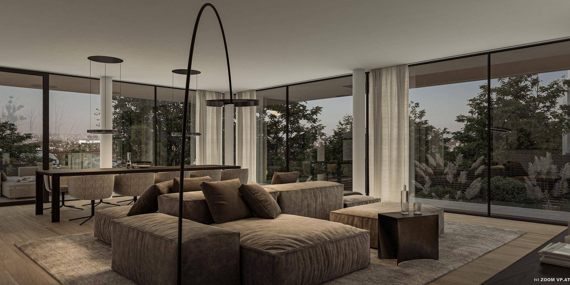Helles Wohnzimmer mit bequemen Sofas und weitem Blick ins Grüne durch große Fensterfronten.