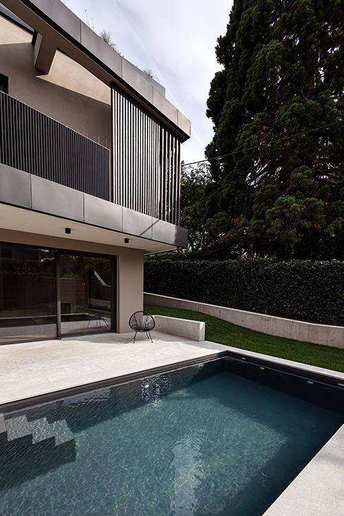 Zeitgenössische Architektur mit kleinem Pool und gepflegtem Gartenbereich, umgeben von hohen Hecken.