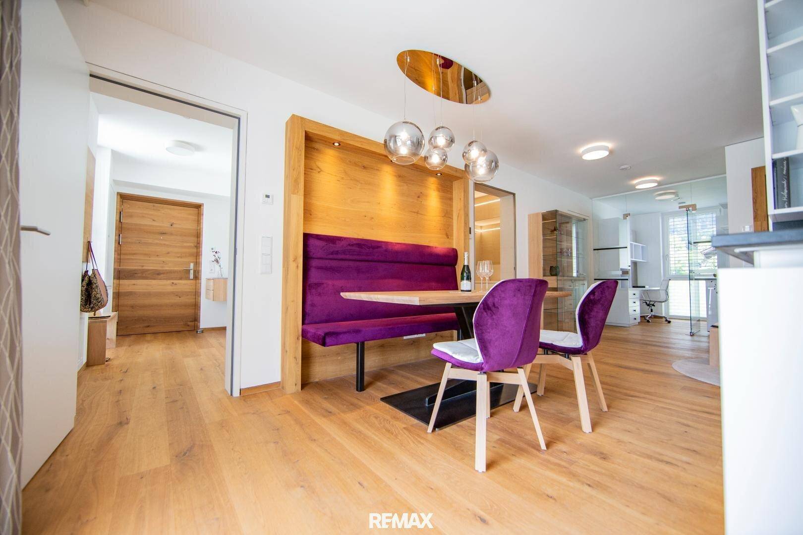 Moderner Essbereich mit violetter Sitzbank, Holztisch und hellem Holzfußboden.