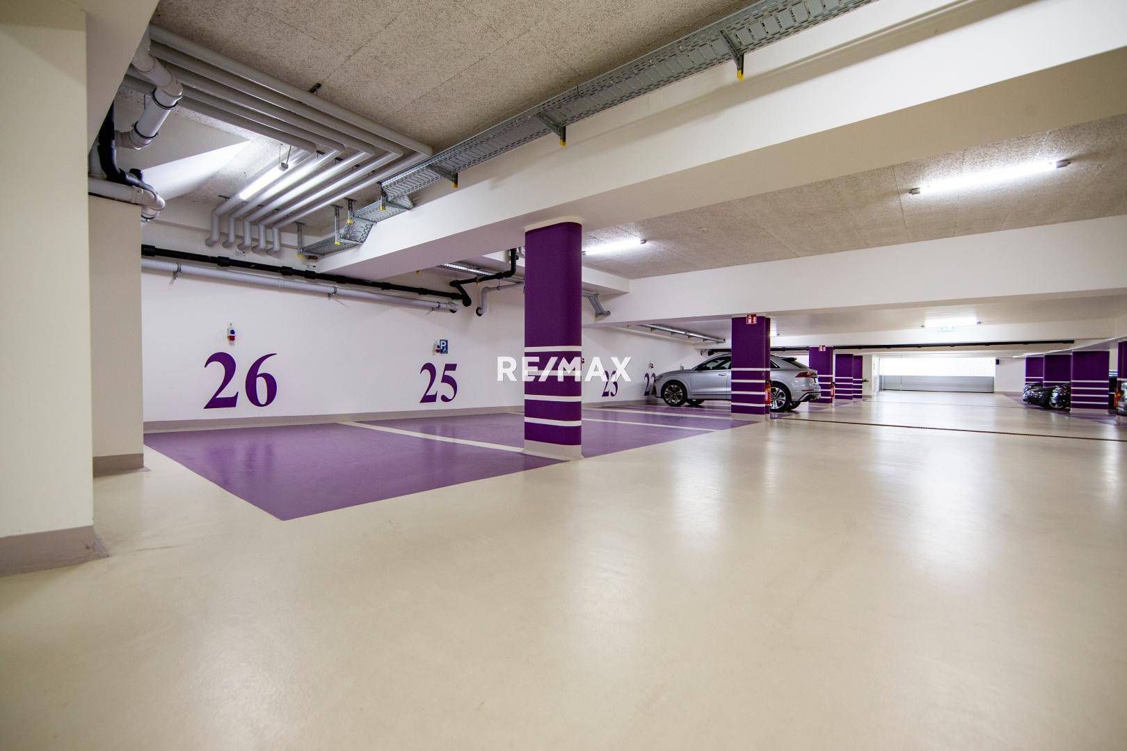 Tiefgarage mit nummerierten Stellplätzen und moderner Beleuchtung.