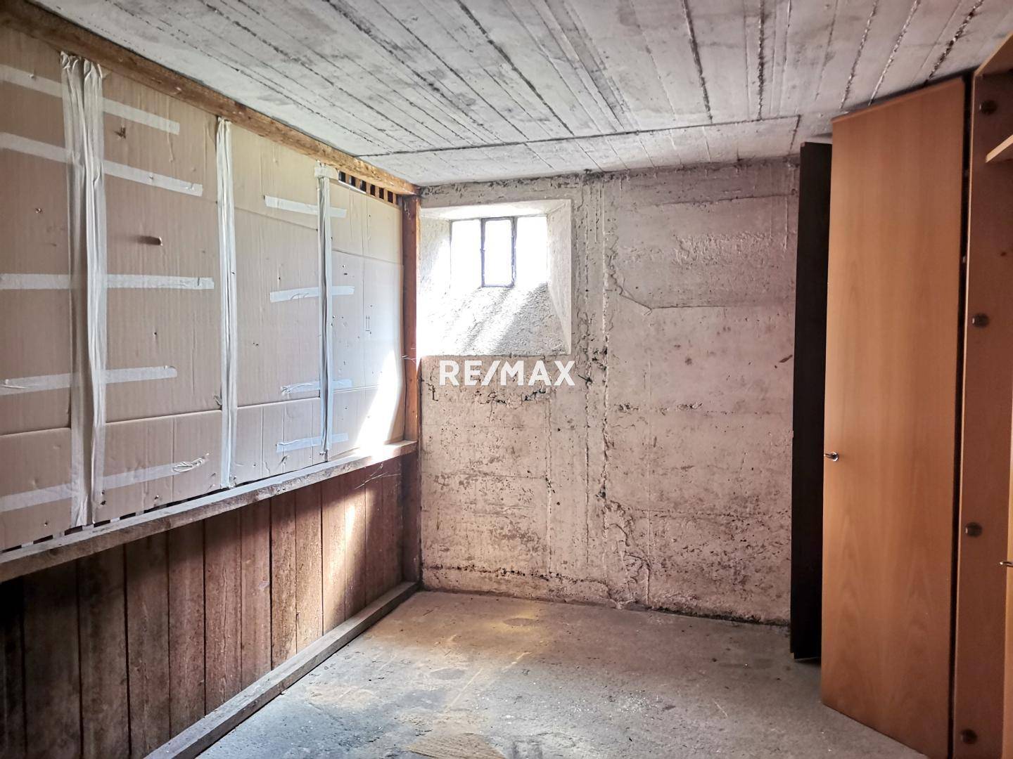 Kellerraum mit Betonwänden und kleinem Fenster, ideal als Abstell- oder Lagerfläche.