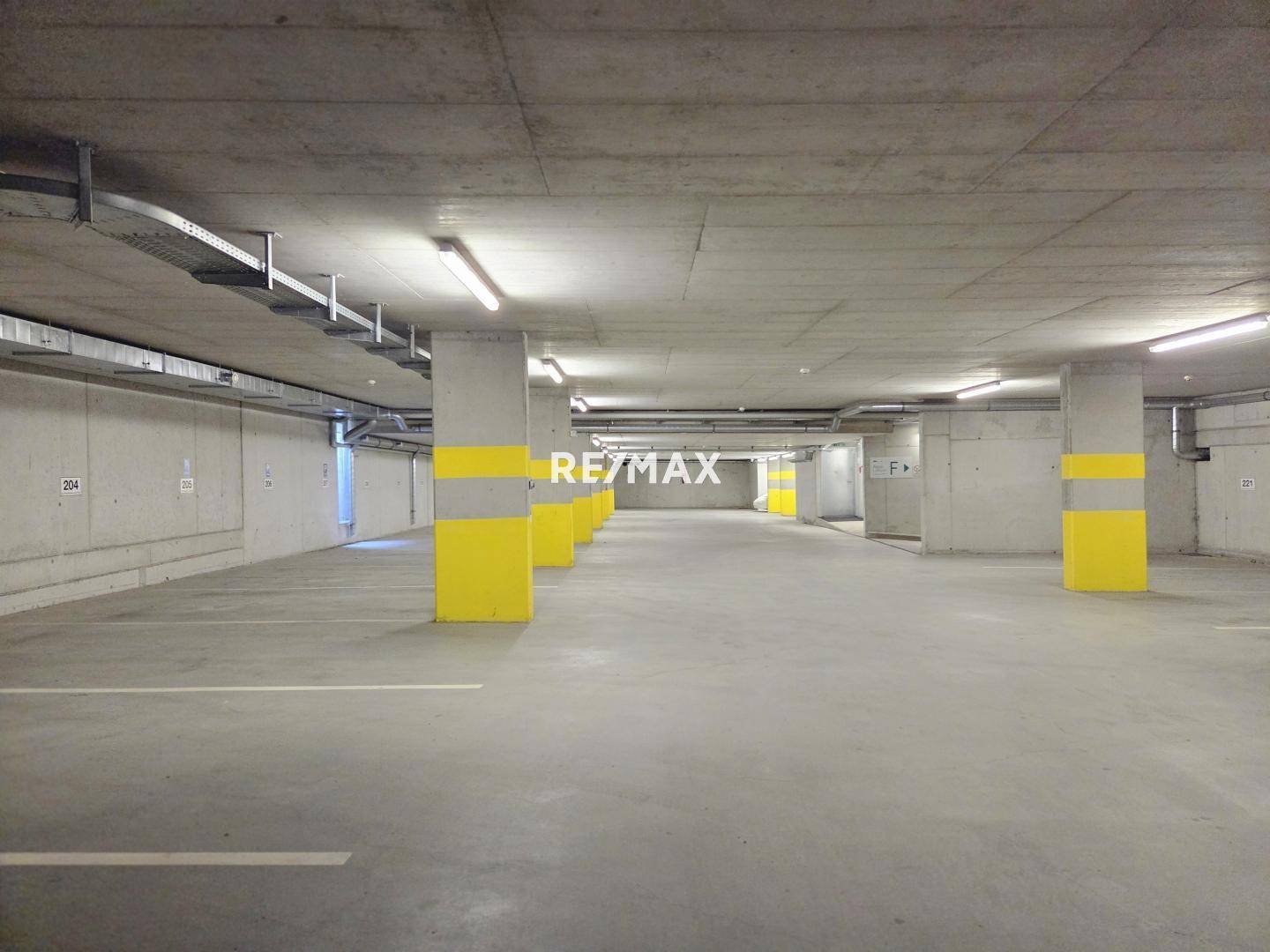 Helle Tiefgarage mit markierten Stellplätzen und guter Beleuchtung, bietet sichere Parkmöglichkeiten.