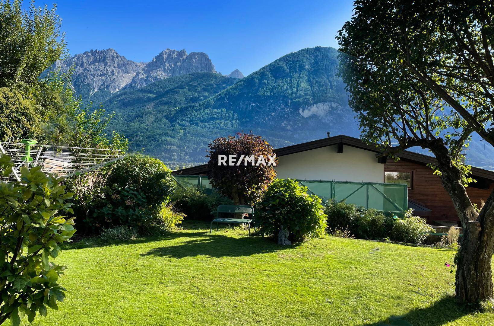 Weitläufiger Garten mit gepflegtem Rasen und beeindruckendem Panoramablick auf die umliegende Bergwelt.