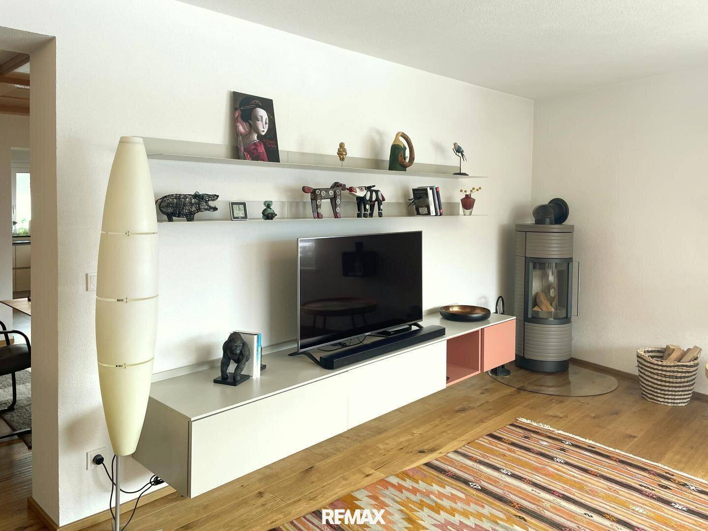 Modernes Wohnzimmer mit Holzboden, Kaminofen und stilvoller Einrichtung.
