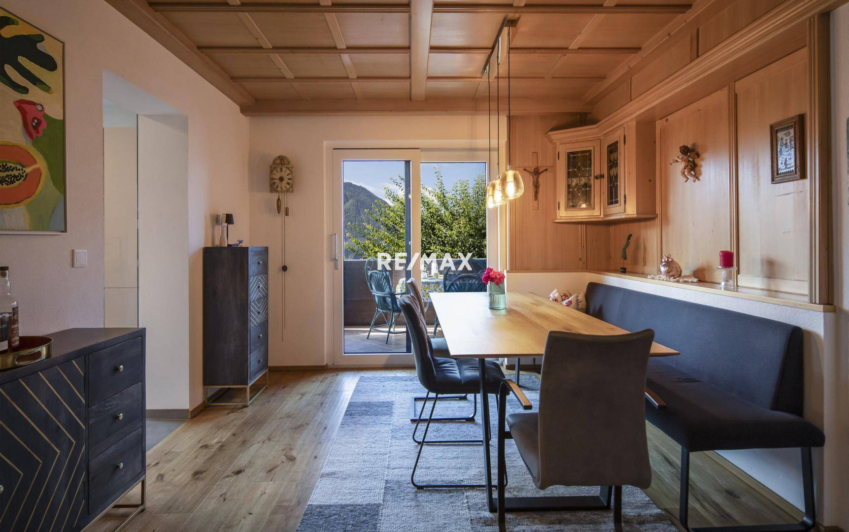 Gemütlicher Essbereich mit Holztäfelung, Kassettendecke und Zugang zum Balkon.