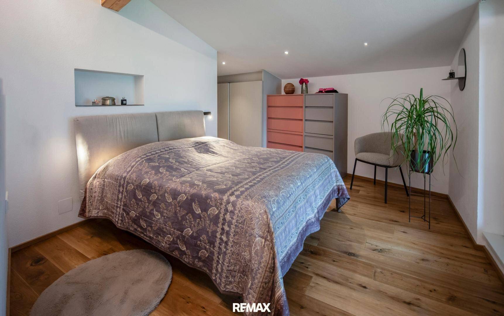 Gemütliches Schlafzimmer mit Holzboden, Doppelbett und Einbauschränken.