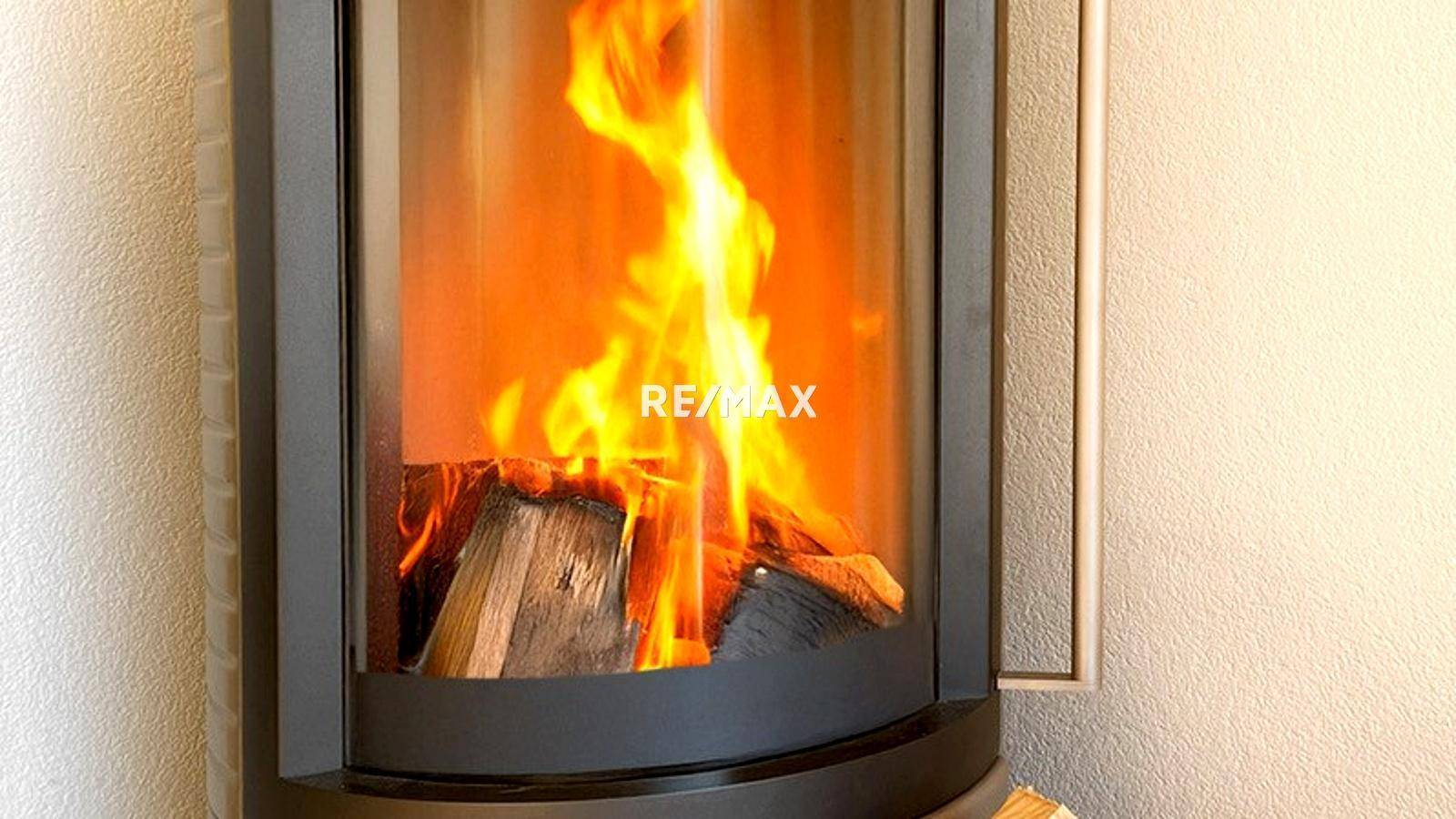 Detailaufnahme eines modernen Kaminofens mit sichtbaren Flammen, der Wärme spendet.