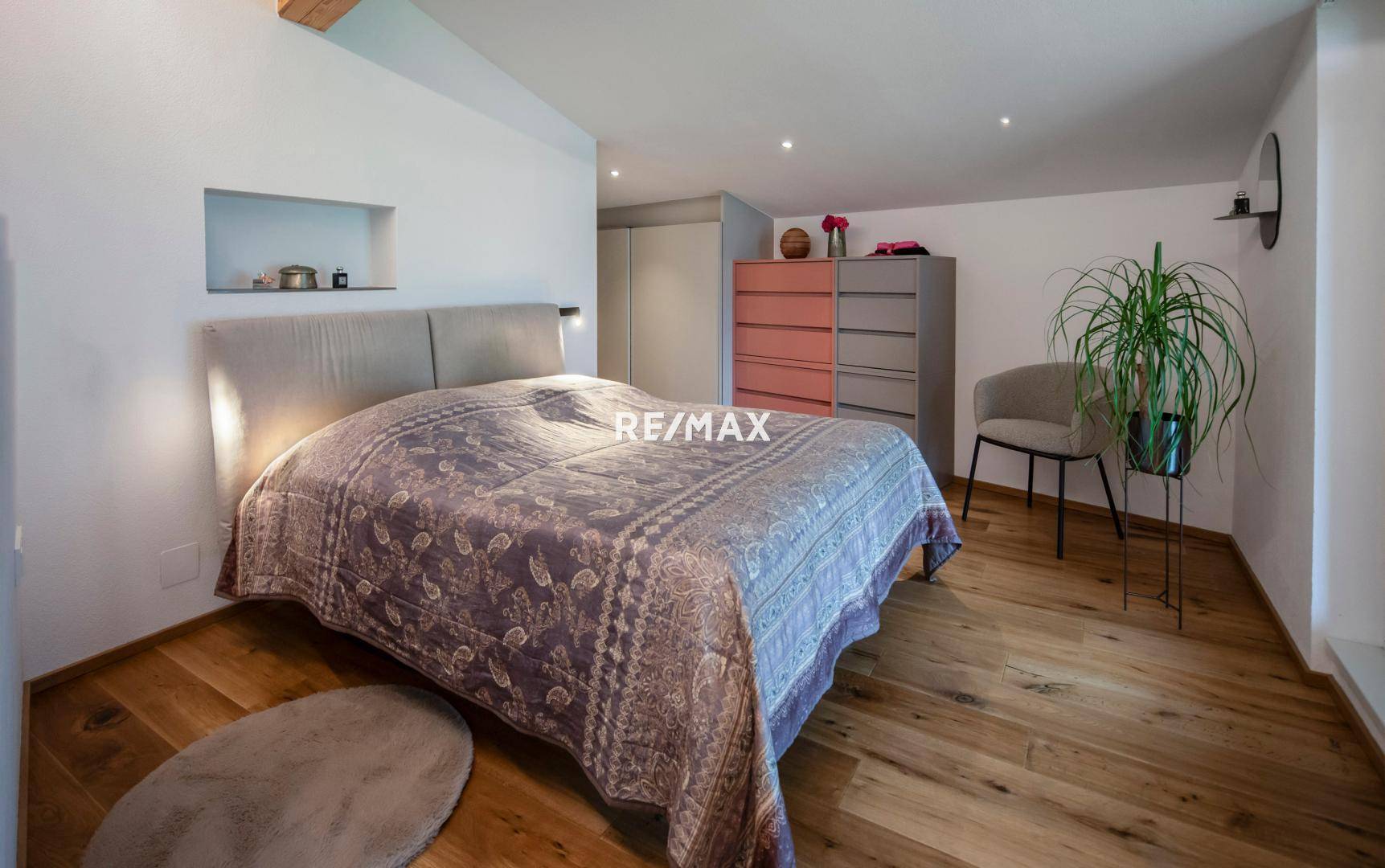 Gemütliches Schlafzimmer mit Holzboden, Doppelbett und integrierten Schränken.