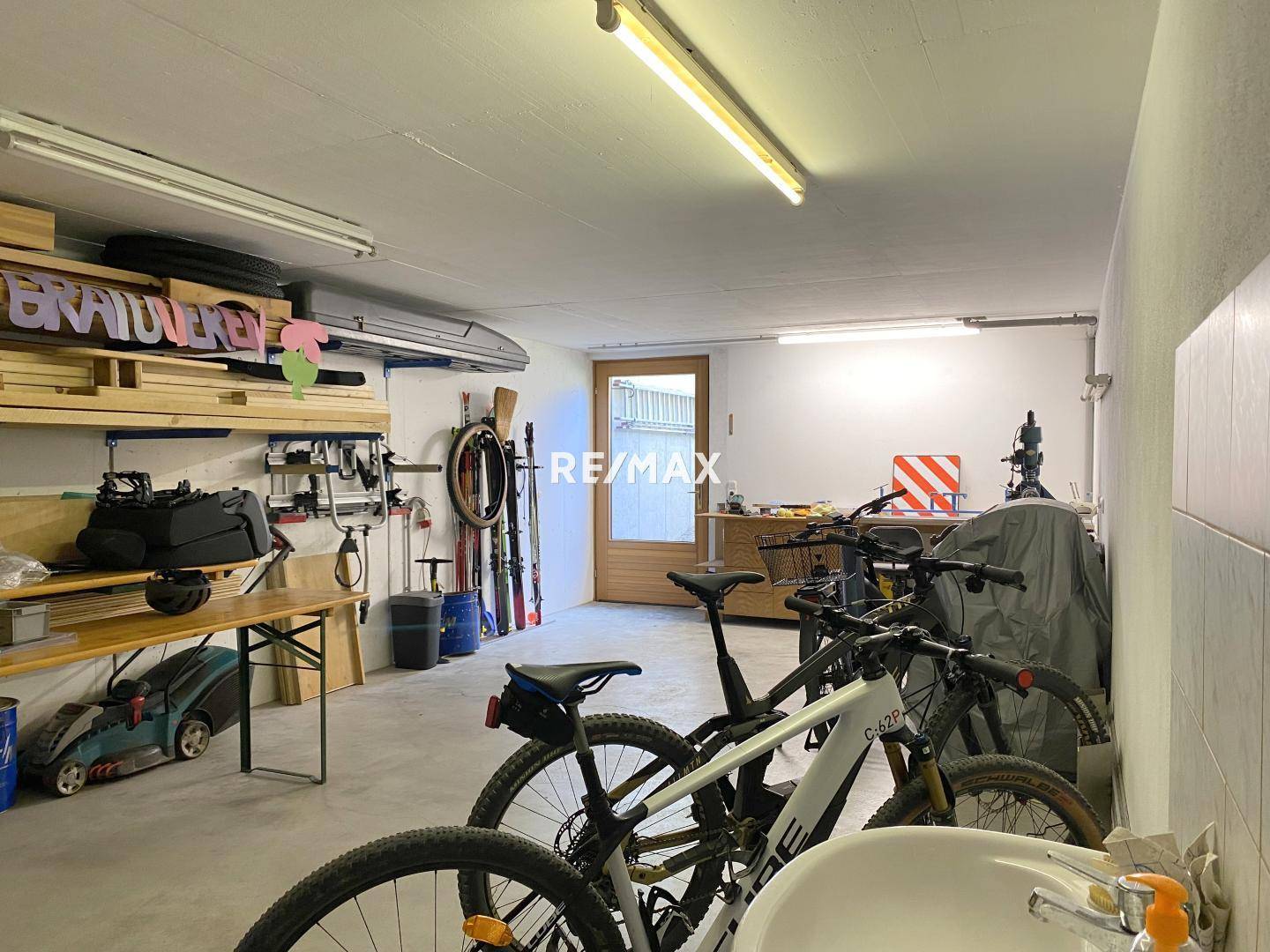 Geräumige Garage mit Werkbank, Stauraum und Platz für Fahrräder und Sportgeräte.