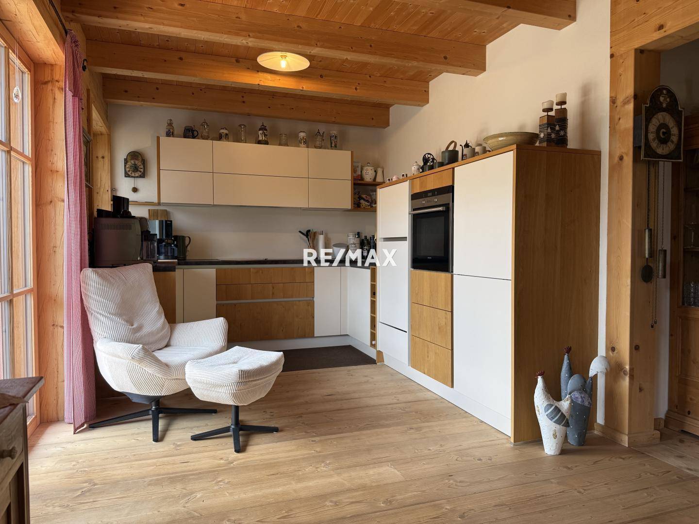 Offene Küche mit modernen Holz- und weißen Fronten, integrierten Geräten und Holzboden.