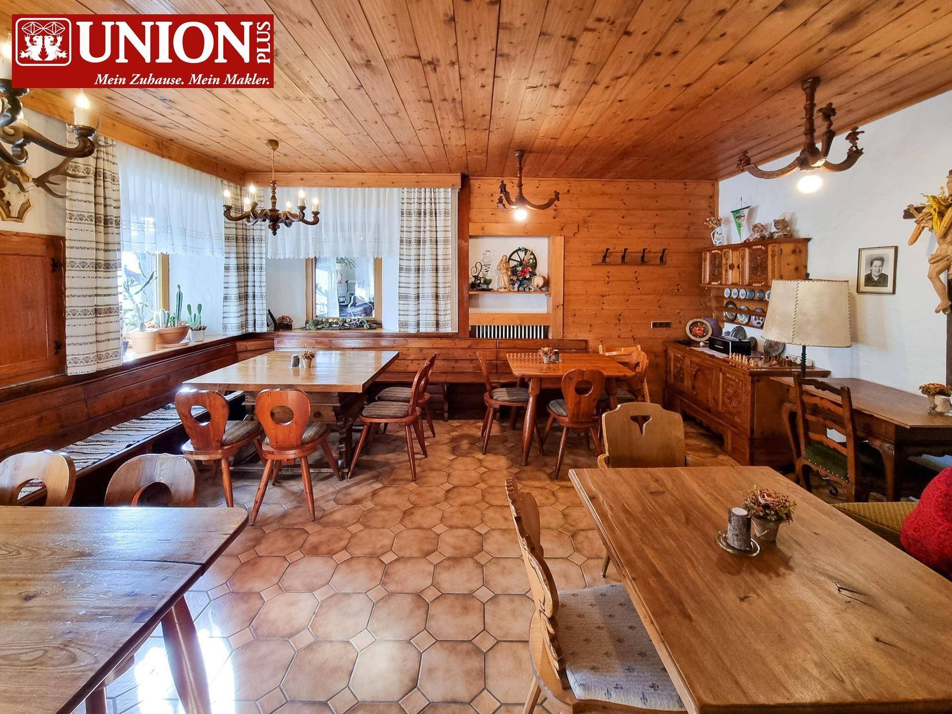 Gemütlicher Speisesaal im traditionellen alpinen Stil mit Holztäfelung und rustikalen Möbeln.