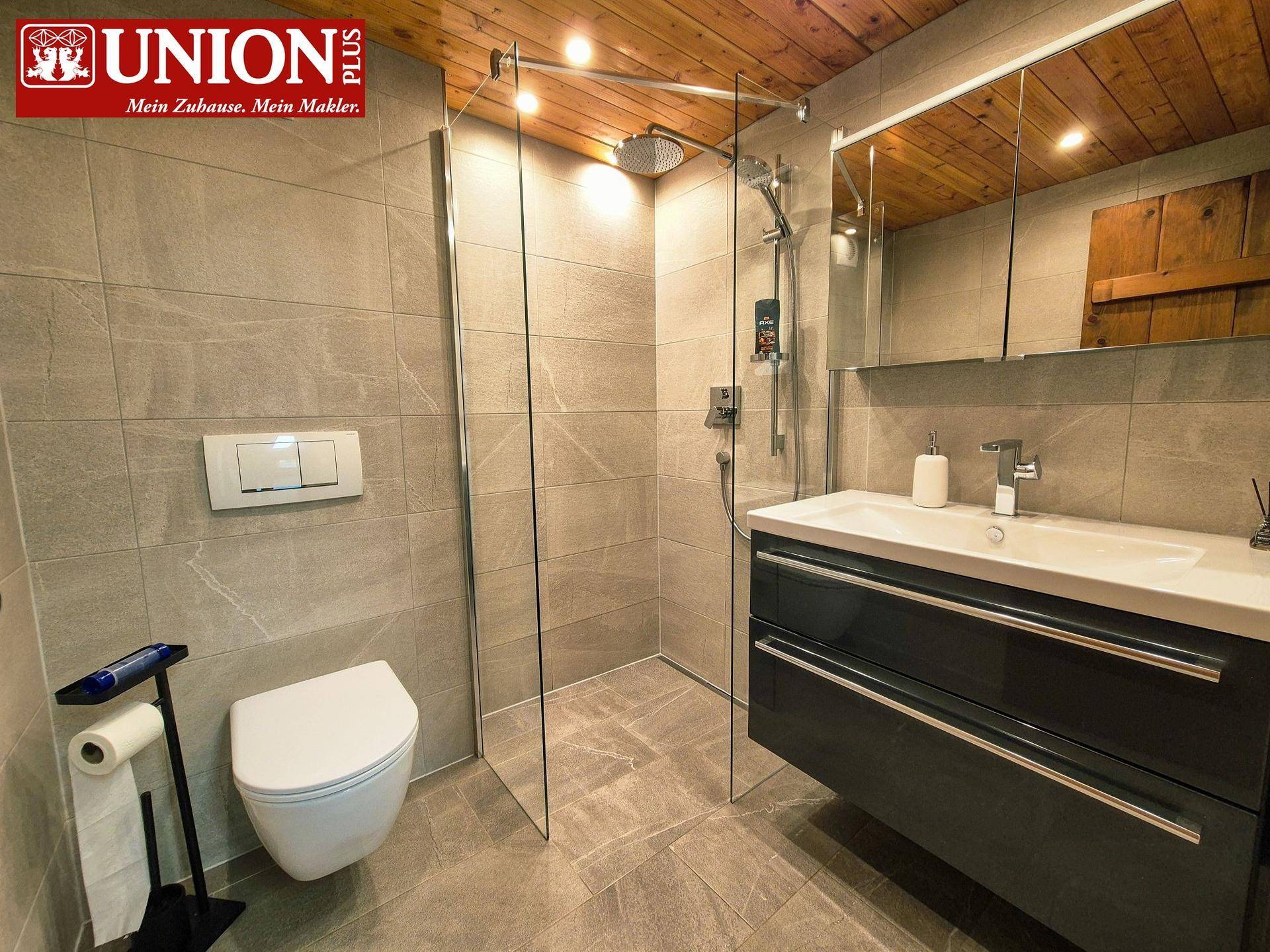 Modernes Badezimmer mit begehbarer Dusche, Wand-WC und stilvollem Waschtisch.