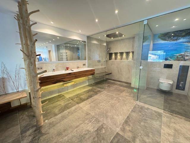 Großes modernes Badezimmer mit Doppelwaschbecken, begehbarer Dusche und separatem WC-Bereich.
