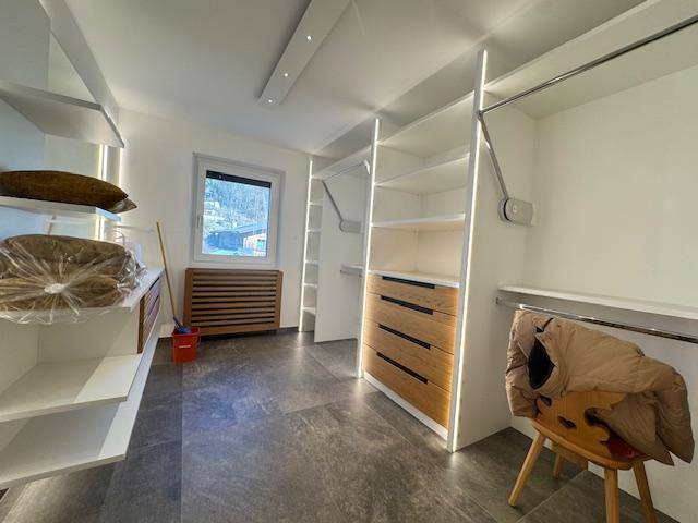 Geräumiger begehbarer Kleiderschrank mit modernen Regalsystemen und Fenster.