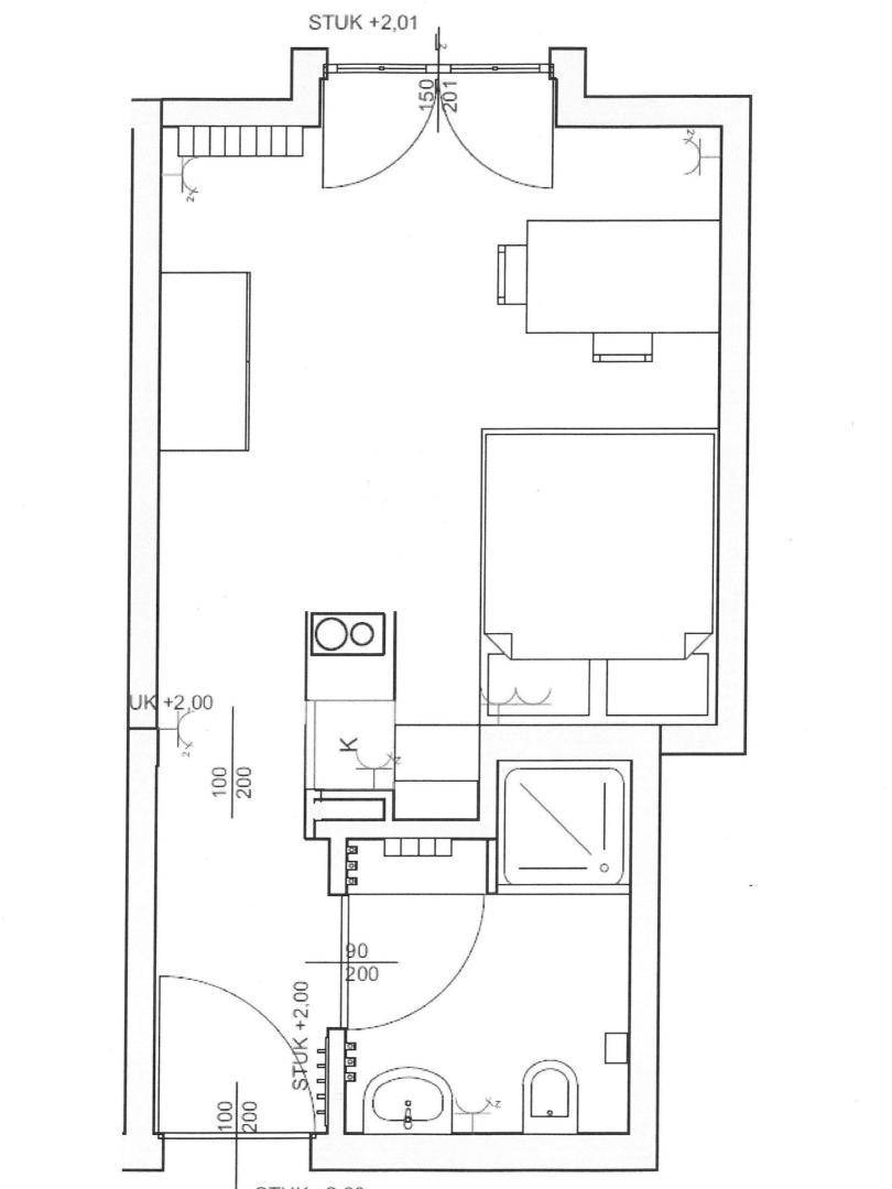 Grundriss einer Wohnung mit Schlafbereich, integrierter Küche und Badezimmer.