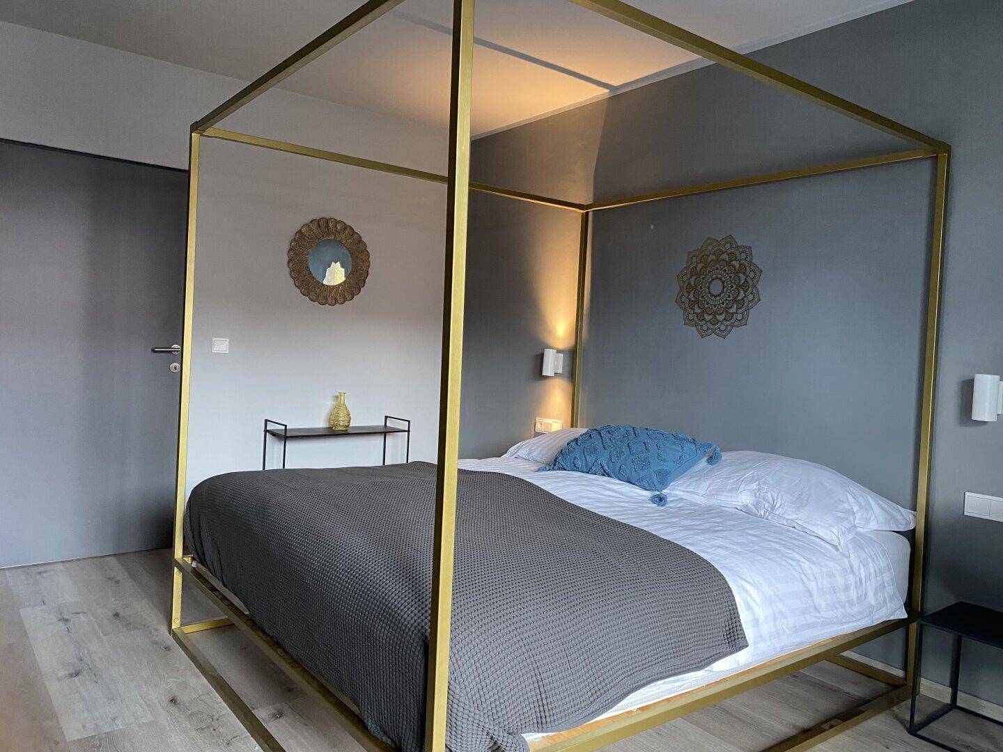 Stilvolles Schlafzimmer mit Himmelbett, modernem Dekor und hellem Boden.
