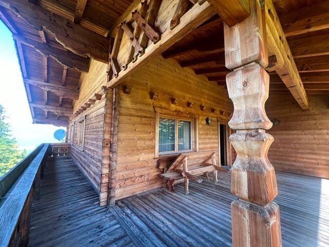 Geräumiger Holzbalkon mit traditionellen Schnitzereien und Sitzgelegenheiten, ideal zum Entspannen.