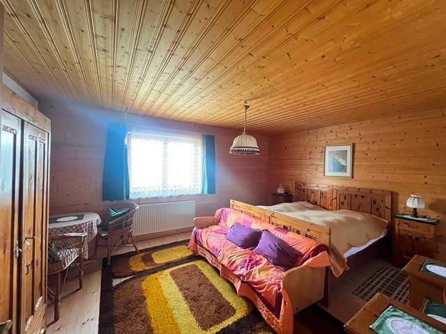 Schlafzimmer mit Holzvertäfelung, Doppelbett und traditionellen Möbeln, hell und freundlich.