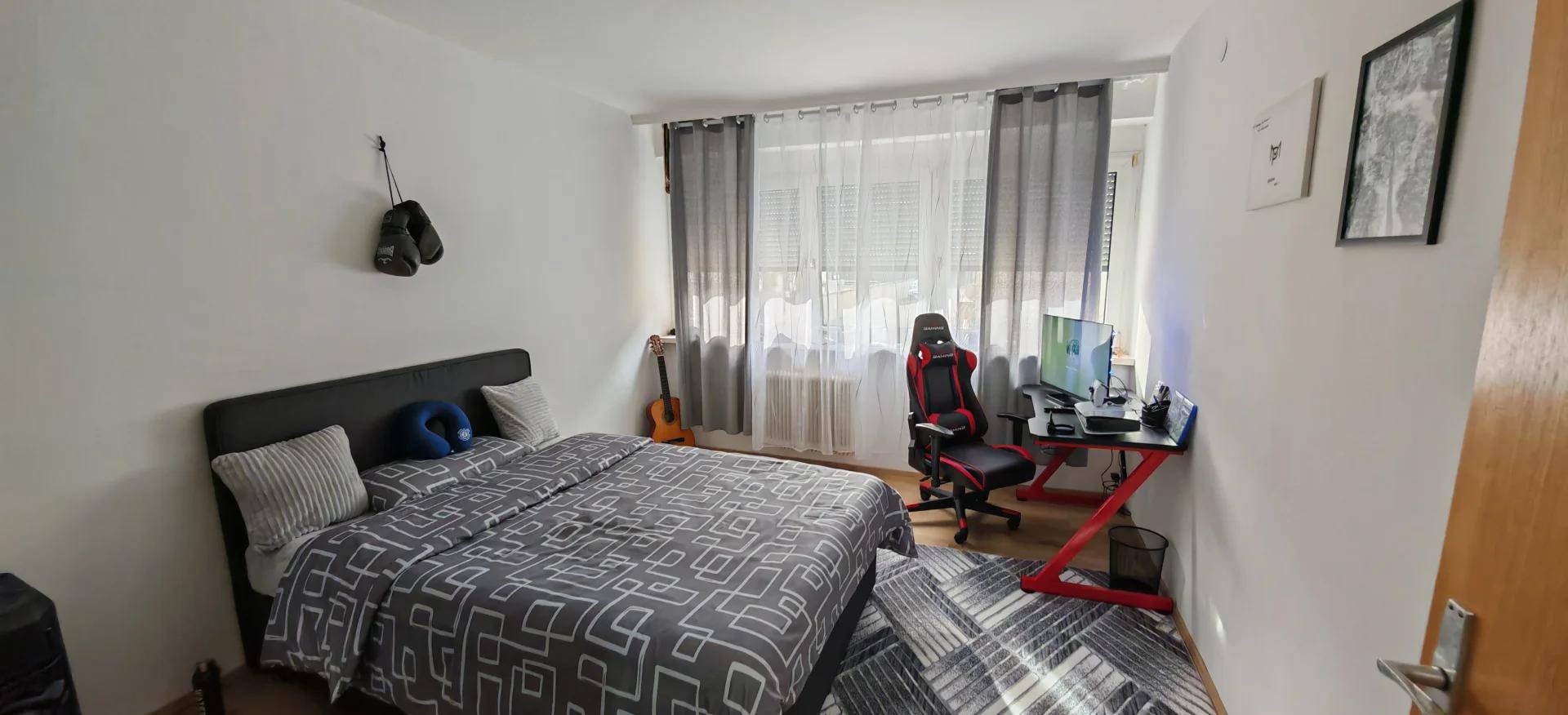 Jugendzimmer mit Bett, Schreibtisch und Gaming-Stuhl, bietet Platz zum Schlafen und Lernen.