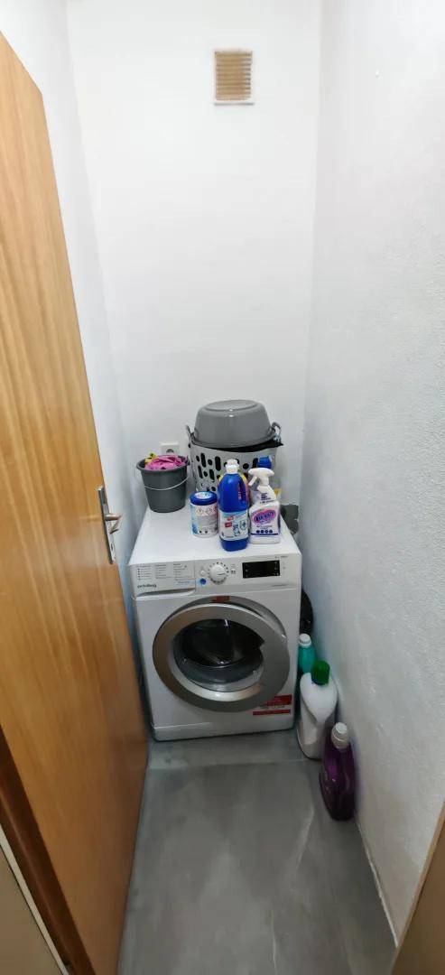 Kleiner Hauswirtschaftsraum mit Waschmaschine und Platz für Reinigungsutensilien.