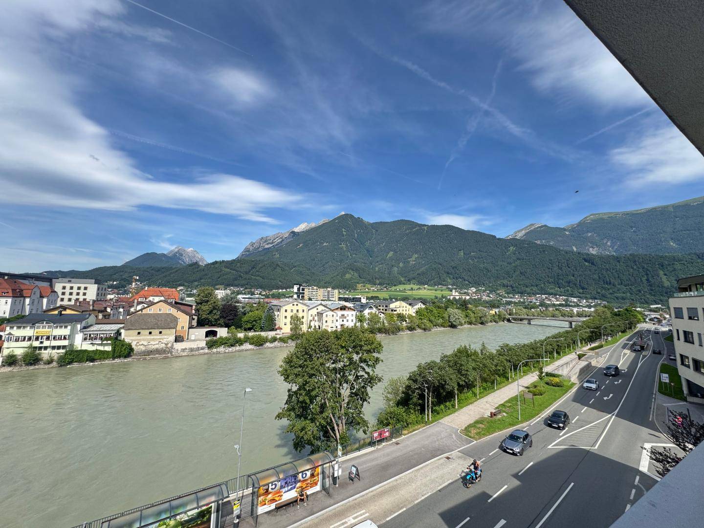 Panoramablick auf den Fluss, die Stadt und die majestätischen Berge im Hintergrund.