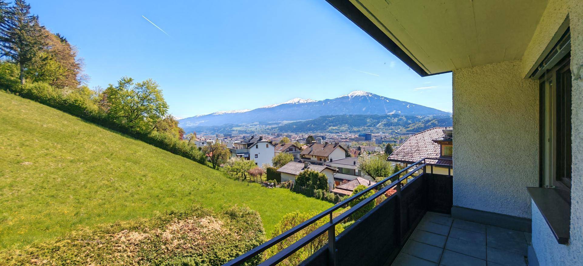 Balkon mit Panoramablick auf die grüne Hügellandschaft und die Stadt im Tal.