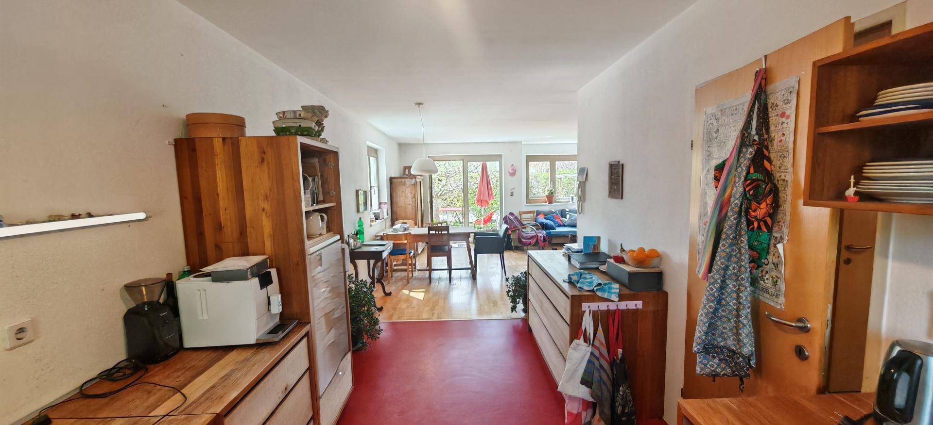 Blick vom Flur in den hellen Wohnbereich mit Zugang zu einem Balkon.