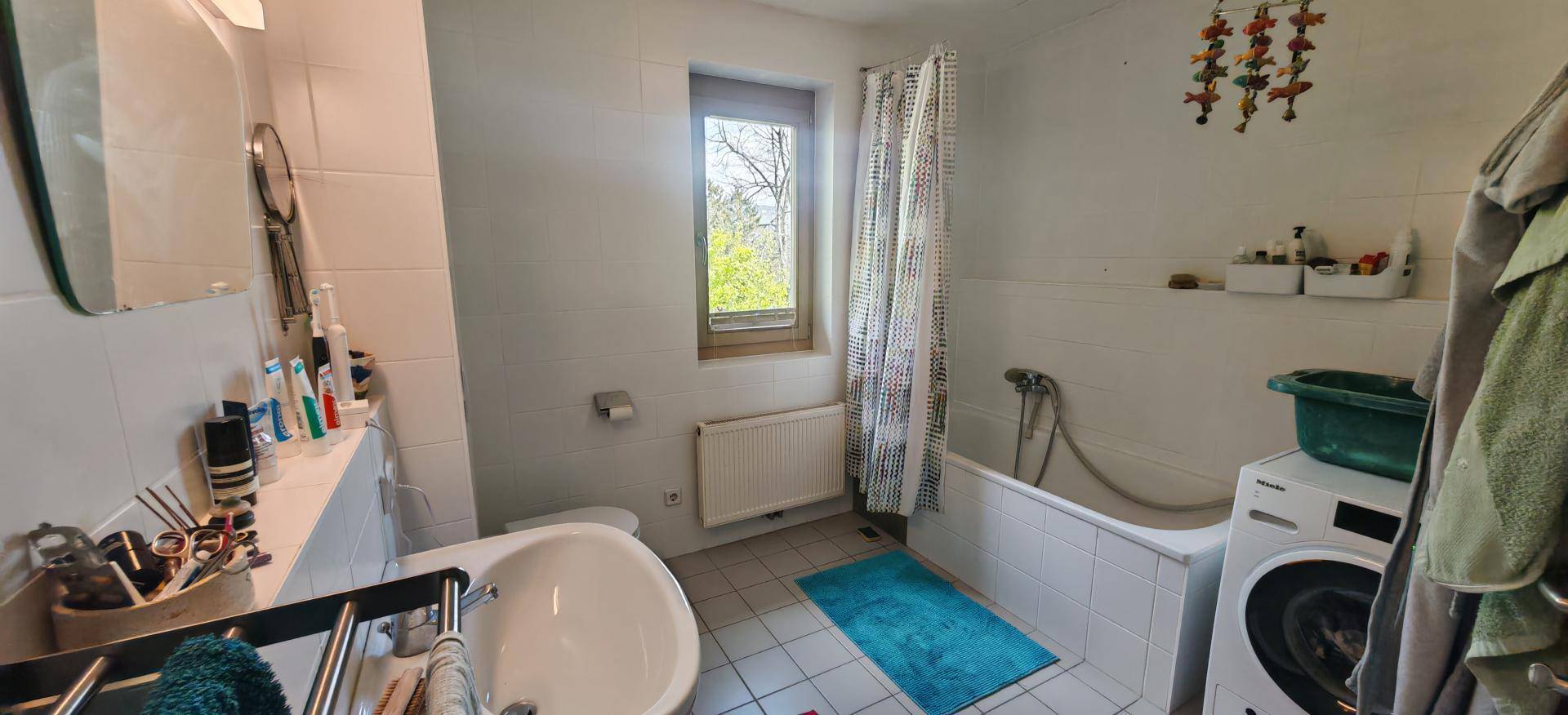 Badezimmer mit Badewanne, Waschbecken, WC und Fenster für gute Belüftung.